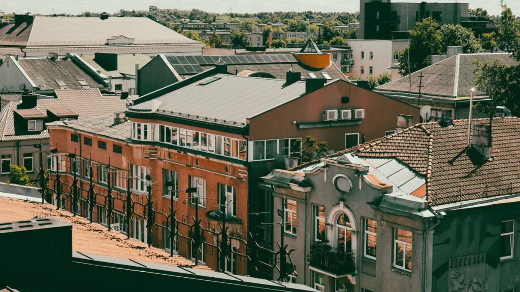 Charming cityscape view of European rooftops beneath a bright summer sky.