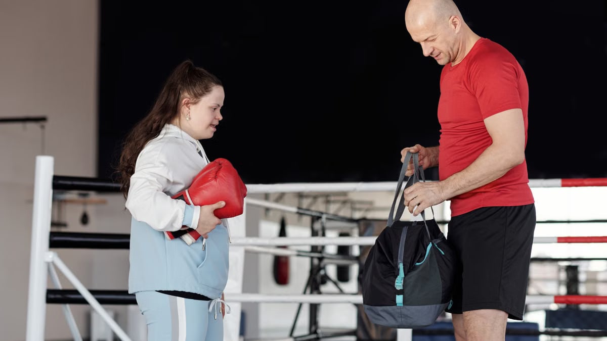 A man and woman with boxing gloves in a gym, promoting inclusivity and fitness.